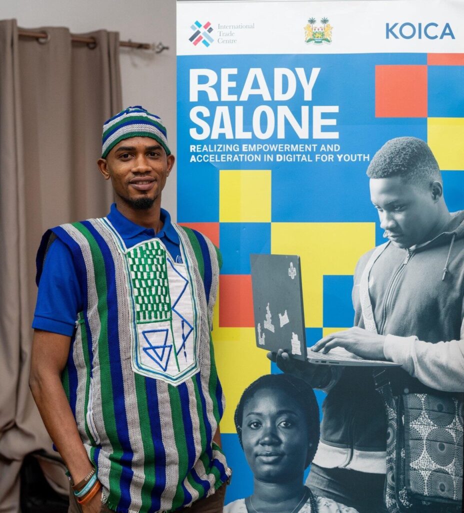 Founder standing beside the READY Salone banner at an e-commerce training